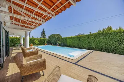 a patio with chairs and a swimming pool at Villa Medicis by Villa Plus in Albufeira