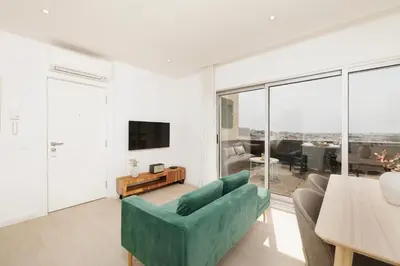 a living room with a couch and a table at Top-Floor 2BR, Sea and city Views & Jacuzzi in Faro