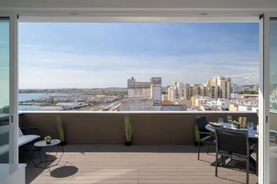 a balcony with a view of a city at Downtown, 1br with a first row view over the sea in Faro