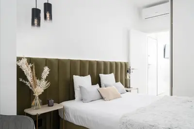 a bedroom with a white bed with a green headboard at Downtown, 1br with a first row view over the sea in Faro