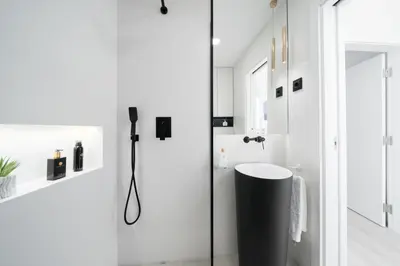a white bathroom with a shower and a sink at Downtown, 1br with a first row view over the sea in Faro