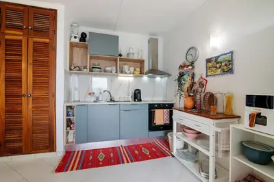 a kitchen and living room with a table and a refrigerator at Maison Jack in Albufeira