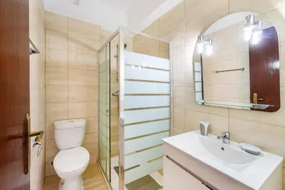 a bathroom with a toilet and a sink and a mirror at Sol & Mar Quarteira in Quarteira