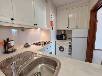 a kitchen with a sink and a white refrigerator at Cimo do Monte Natur by SAPvillas in Vilamoura