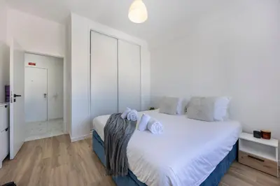 a white bedroom with a large bed with white sheets at Nordic Breeze in Quarteira