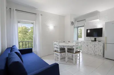 a living room with a blue couch and a table at Sun & Sea Flat in Quarteira - Cozy Apartment Close to the Beach, by Hopstays in Quarteira