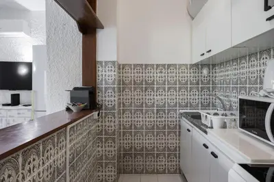 a kitchen with white cabinets and a tile wall at Sun & Sea Flat in Quarteira - Cozy Apartment Close to the Beach, by Hopstays in Quarteira