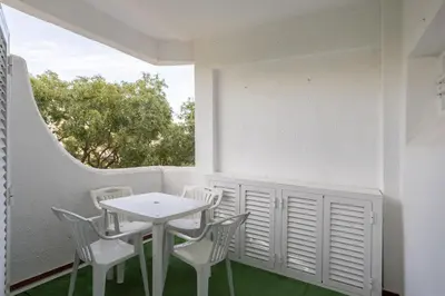 a white table and chairs on a balcony with a window at Sun & Sea Flat in Quarteira - Cozy Apartment Close to the Beach, by Hopstays in Quarteira