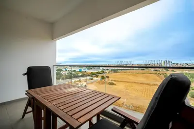 a dining room with a table and chairs and a large window at HolidaysPT - Sunset At Lux Terrace - 2 Bedroom Apt in Faro