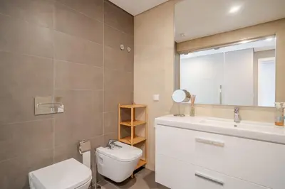 a bathroom with a toilet and a sink and a mirror at HolidaysPT - Sunset At Lux Terrace - 2 Bedroom Apt in Faro