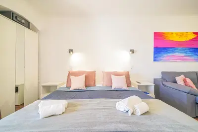 a bedroom with a large bed with a blue couch at Romantic Studio by Moje Holiday in Albufeira