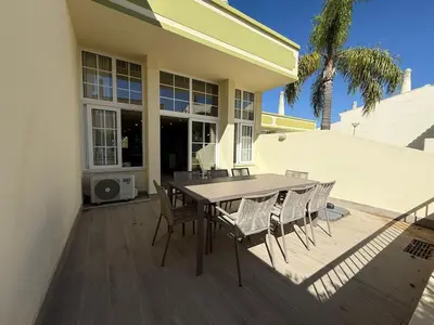 a patio with a table and chairs on a deck at Villa 23 - Ponta Grande Resort in Albufeira