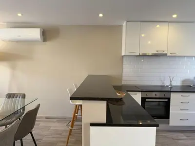 a kitchen with white cabinets and a black counter top at Villa 23 - Ponta Grande Resort in Albufeira