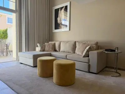 a living room with a couch and two stools at Villa 23 - Ponta Grande Resort in Albufeira