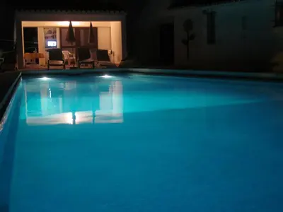 a large blue swimming pool at night at Your villa in Vilamoura in Quarteira