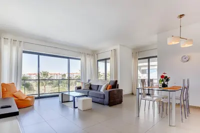 a living room with a couch and a table at Cavalo Preto Beach Resort Apt & Wi-Fi Nr Beach in Quarteira