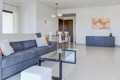 a living room with a couch and a table at Cavalo Preto Beach Resort Apt & Wi-Fi Nr Beach in Quarteira