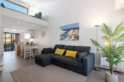 a living room with a couch and a dining room at Casa do Sol and Golf - Vilamoura in Vilamoura