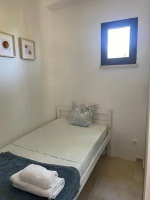 a small bed in a room with a window at Estúdio na Falésia 2 in Olhos de Água