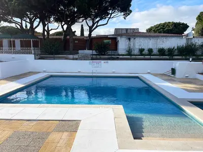 a swimming pool with blue water in a yard at Estúdio na Falésia 2 in Olhos de Água