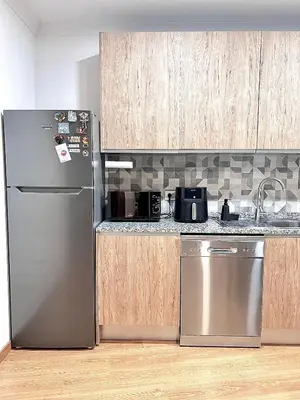 a kitchen with a stainless steel refrigerator and wooden cabinets at OMG Faro in Faro