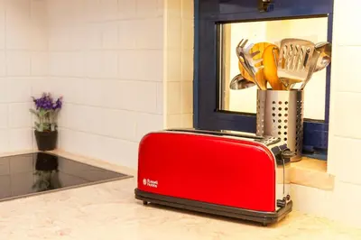 a red toaster sitting on a counter in a kitchen at Vila Sol F5 Vilamoura 2BR by Enjoy your stay in Quarteira