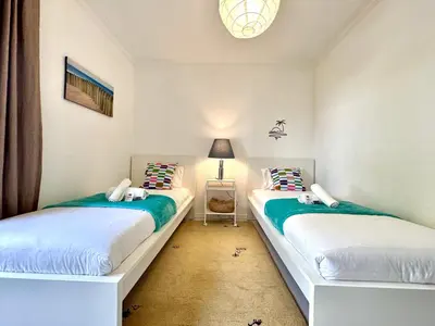 two twin beds in a room with a lamp at Vilamoura Brightness Apartment with Pool by Homing in Vilamoura