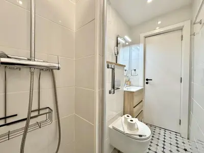 a white bathroom with a shower and a toilet at Vilamoura Brightness Apartment with Pool by Homing in Vilamoura