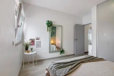 a white bedroom with a bed and a mirror at Casa Machadinho in Albufeira