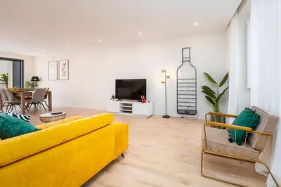 a dining room and living room with a table and chairs at Casa De Mariposas Viola in Faro