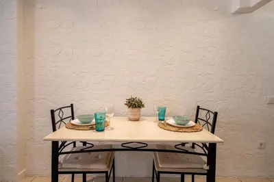 a table with two chairs and a white wall at Studio 39 Downtown in Faro