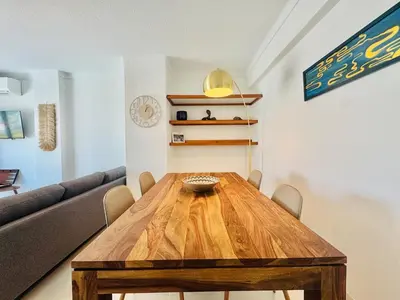 a living room with a wooden table and a couch at Doble Vista Faro, Terrace with View, AC & WiFi in Faro