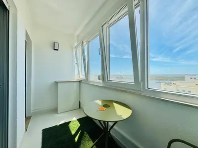 a small table in a room with two windows at Doble Vista Faro, Terrace with View, AC & WiFi in Faro