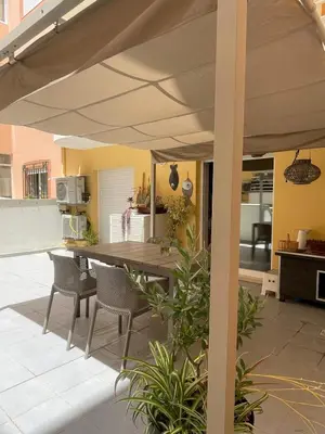 an outdoor kitchen with a table and chairs under a patio umbrella at City Dreams in Faro