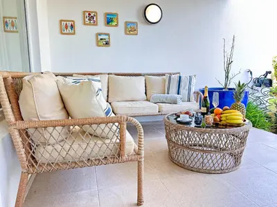 a living room with a wicker chair and a couch at Windmill Hill Gem Townhouse By BeCherish in Albufeira
