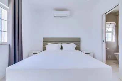 a bedroom with a large white bed with white sheets at Casa Nuria com 4 quartos, piscina e churrasco em Vale do Lobo in Almancil