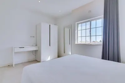 a white bedroom with a bed and a window at Casa Nuria com 4 quartos, piscina e churrasco em Vale do Lobo in Almancil