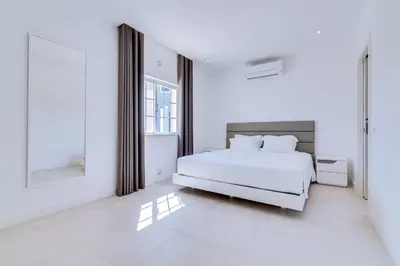 a white bedroom with a bed and a window at Casa Nuria com 4 quartos, piscina e churrasco em Vale do Lobo in Almancil