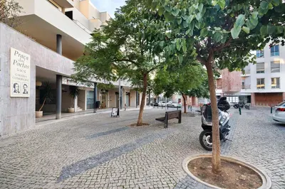 a scooter parked next to two trees on a street at Happy House Central Apartment in Faro
