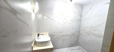 a bathroom with white marble walls and a sink at Ocean life in Albufeira