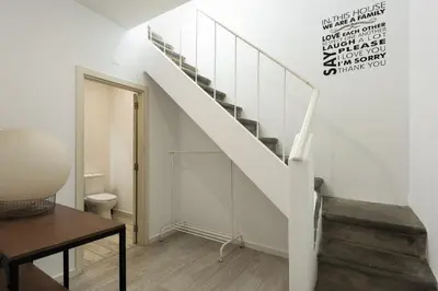 a staircase in a living room with a table and a stair case at Marggisa - City Center by HD in Faro