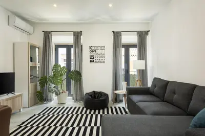 a living room with a couch and a tv at Marggisa - City Center by HD in Faro