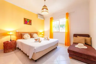 a bedroom with a large bed and a couch at Villa Mare in Albufeira
