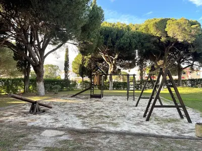 a park with a playground with two swings at Refúgio junto à falésia in Olhos de Água