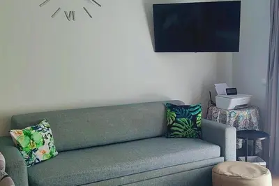 a living room with a green couch and a television at Apartment - Sleeps 2 - Pool - Parking - Balcony in Albufeira