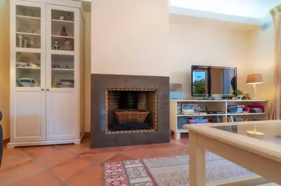 a living room with a fireplace in the middle at 3 Quartos, Piscina, AC, Garagem, Prestige For Home in Faro