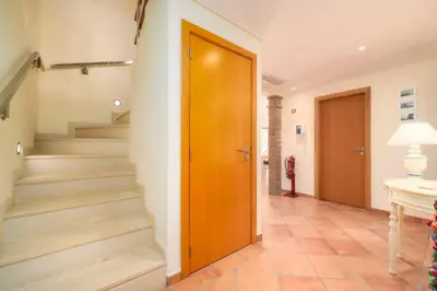 a hallway with stairs and a wooden door at 3 Quartos, Piscina, AC, Garagem, Prestige For Home in Faro