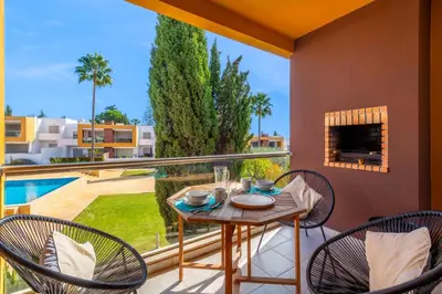 a patio with a table and chairs on a balcony at Apartamento Vista Piscina in Guia