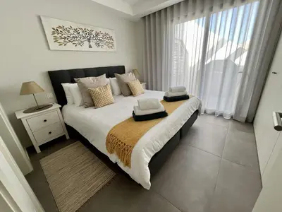 a bedroom with a large bed with a large window at Villa Soligolf - Vilamoura, Algarve in Quarteira