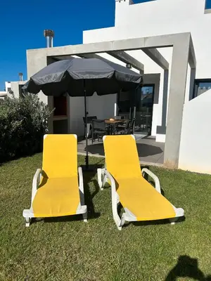 two yellow chairs in the grass in front of a house at Villa Soligolf - Vilamoura, Algarve in Quarteira